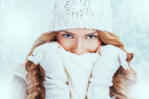 Blue eyed woman hiding her face with a scarf